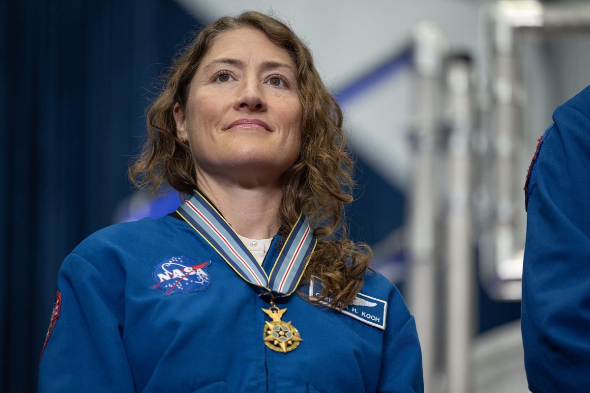 NASA astronaut Christina Koch smiles at the crowd wearing her blue flight jacket and her Congressional Space Medal of Honor.