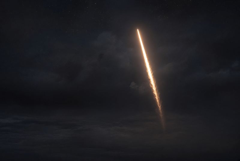 Illustration: a rocket's plume climbing through a night sky. Not a photo of this launch.
